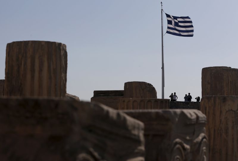 © Reuters. A Greek national flag flutters as tourists visit the Acropolis hill archaeological site in Athens