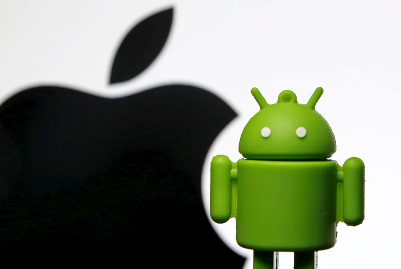© Reuters. Android mascot is seen in front of a displayed logo of Apple in this photo illustration taken in Zenica