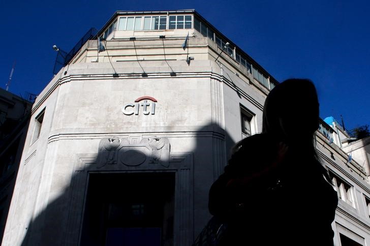 © Reuters. Woman is silhouetted as she walks past Citibank headquarters in Buenos Aires' financial district