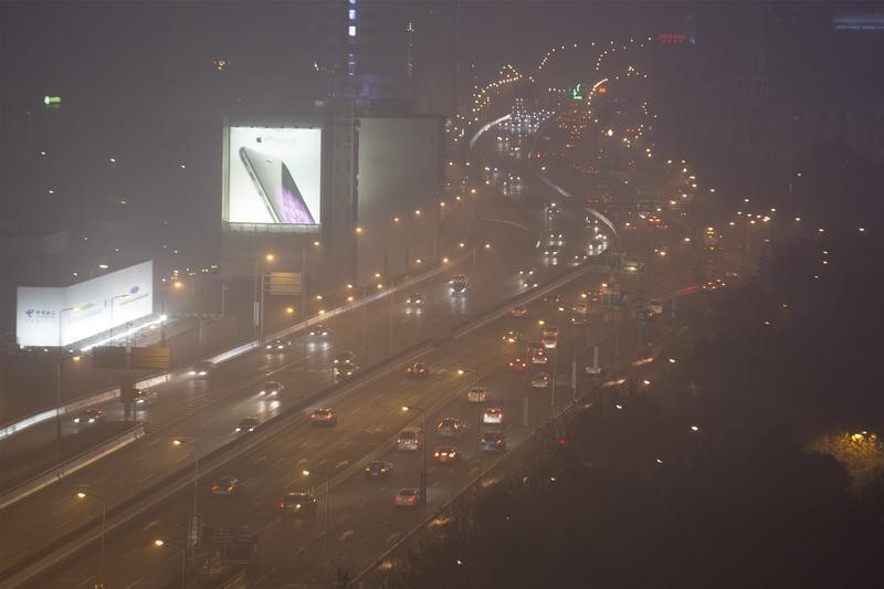 © Reuters. Cars drive on a highway on a hazy night in downtown Shanghai