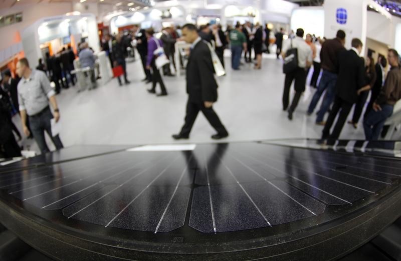 © Reuters. People walk past photovoltaic panels during 'Intersolar' Europe trade fair in Munich