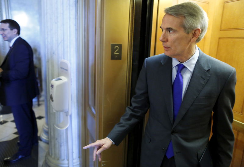 © Reuters. Portman talks to a staff member as he boards an elevator after speaking on the floor of the U.S. Capitol in Washington