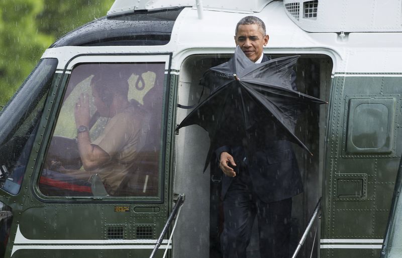 © Reuters. U.S. President Obama opens an umbrella as he steps from Marine One during a rain shower in Washington