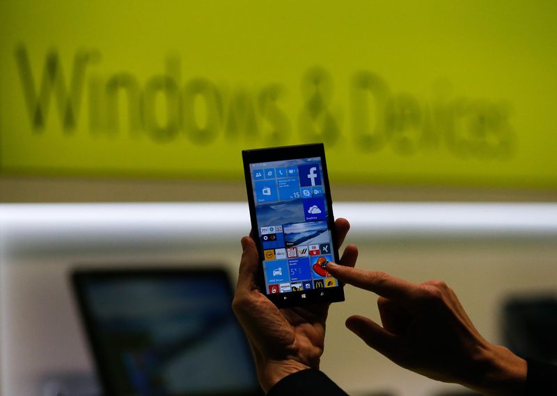 © Reuters. A Microsoft representative shows a smartphone with Windows 10 operating system at the CeBIT trade fair in Hanover in this file photo