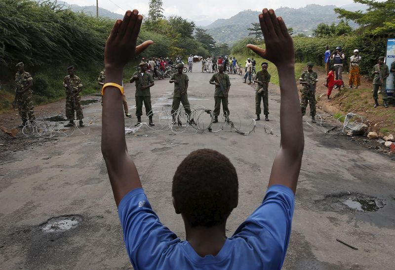 © Reuters. Protester holds his hands up in front of soldiers during a protest against Burundi President Pierre Nkurunziza and his bid for a third term in Bujumbur