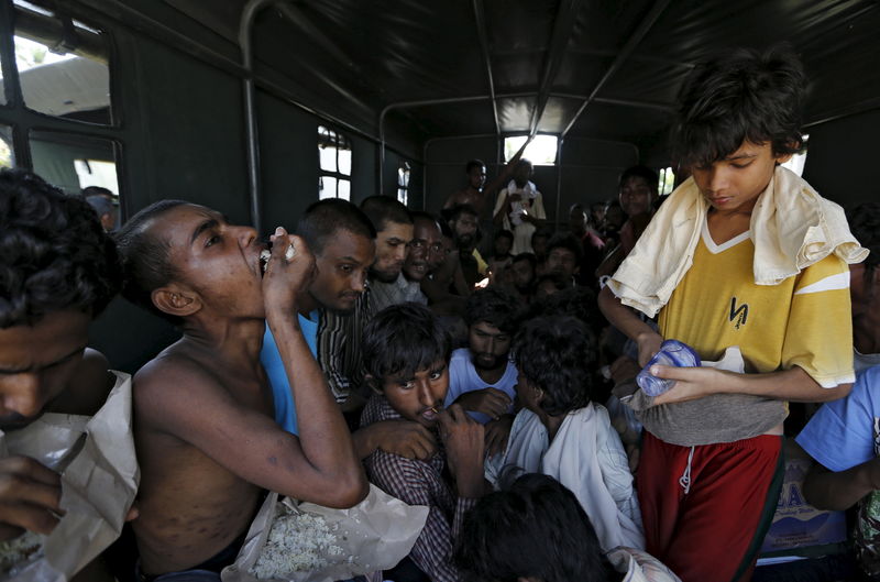 © Reuters. Bangladeshi migrants who arrived by boat sit inside a military truck as they are transported to an immigration office at the port of Julok village in Kuta Binje