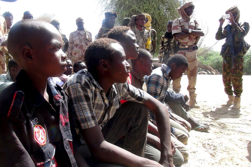 © Reuters. Former members of insurgent group Boko Haram gather in front of Chadian soldiers in Ngouboua