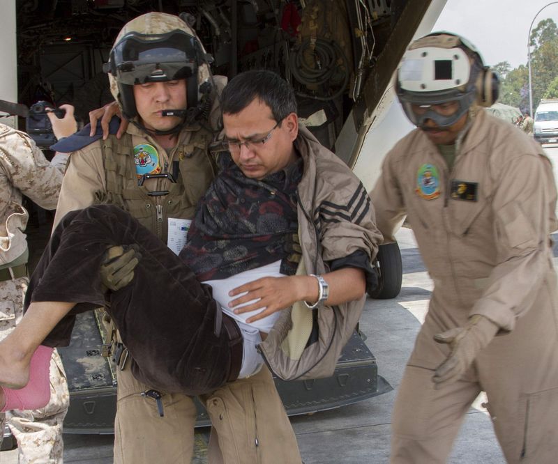 © Reuters. U.S. Service members from Joint Task Force 505 unload casualties of a second earthquake to a medical triage area in Kathmandu