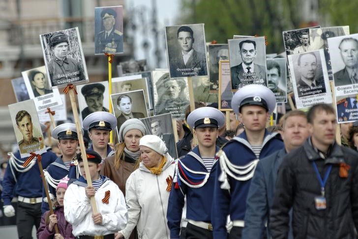 © Reuters. Recrutas e cadetes russos marcham com retratos de familiares que participaram da Segunda Guerra Mundial