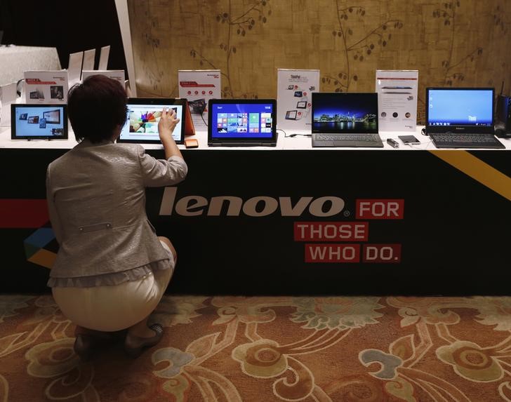 © Reuters. A woman tries a Lenovo tablet on display during a news conference announcing the company's annual results in Hong Kong