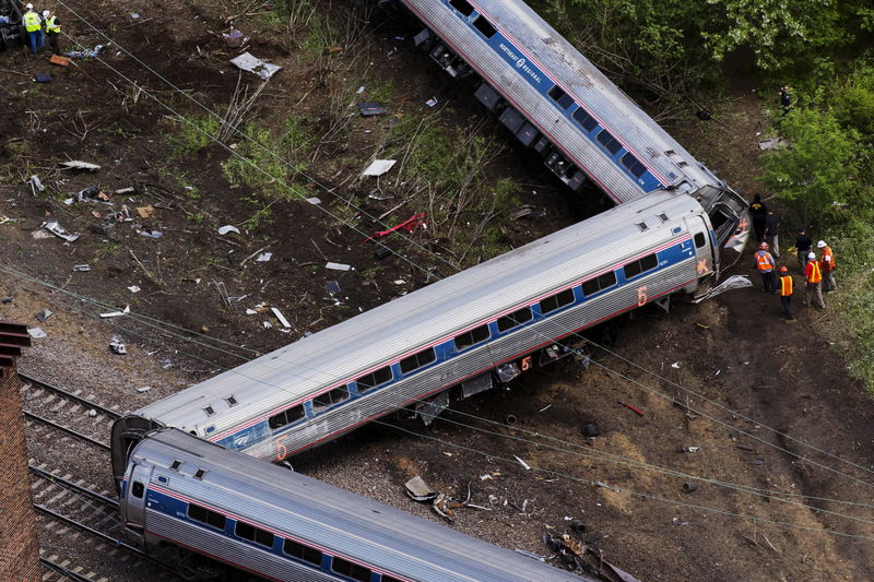 © Reuters. Emergency workers and Amtrak personnel inspect a derailed Amtrak train in Philadelphia, Pennsylvania