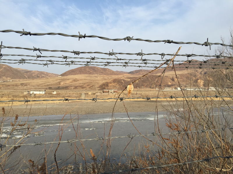 © Reuters. A barbed-wire fence separating North Korea from China is seen in this photo taken from the Chinese border city of Hunchun