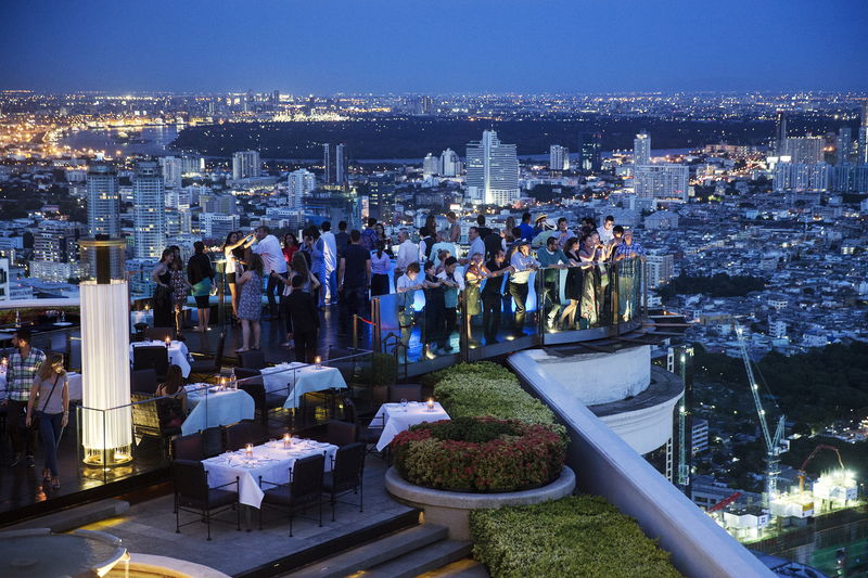 © Reuters. Visitors and tourists enjoy their drinks and the view from a rooftop bar in central Bangkok