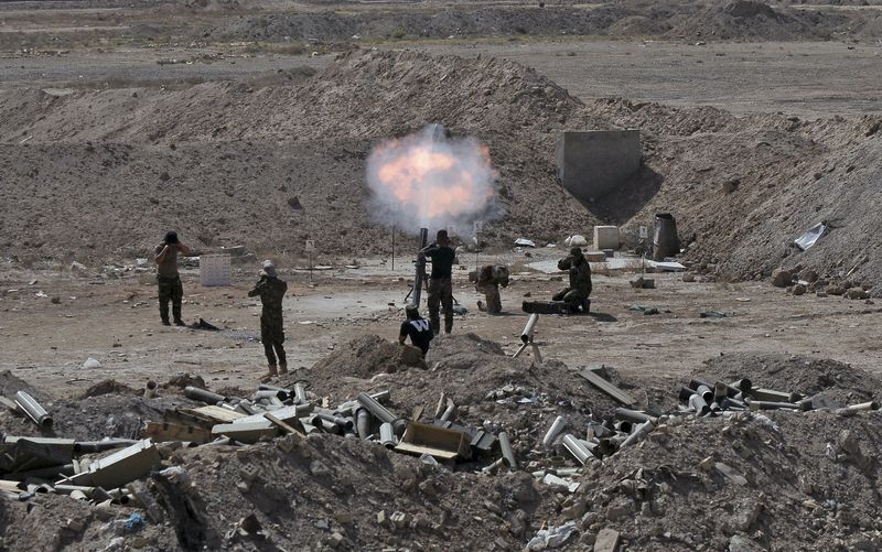 © Reuters. Members of the Iraqi army and Shi'ite fighters launch a mortar toward Islamic State militants outskirt the city of Falluja