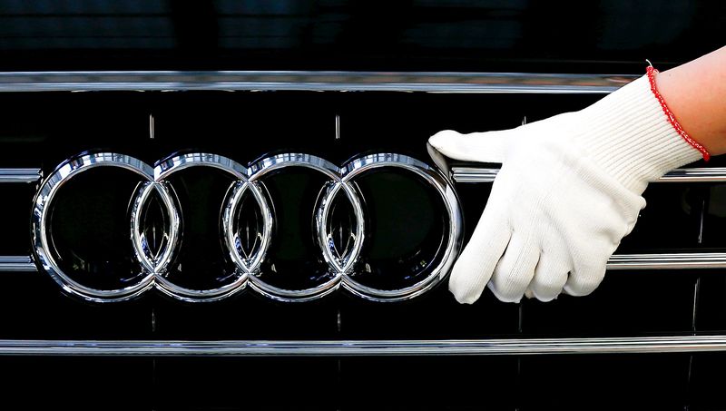 © Reuters. Worker fixes a car emblem as he assembles Audi A8 models at their plant in Neckarsulm near Heilbronn