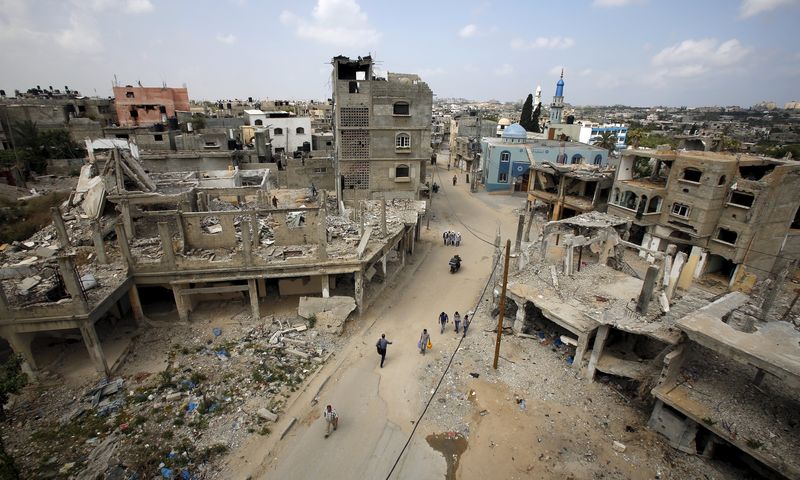 © Reuters. Palestinos andam pelas ruínas de casas destruídas durante conflitos em 2014, no norte de Gaza