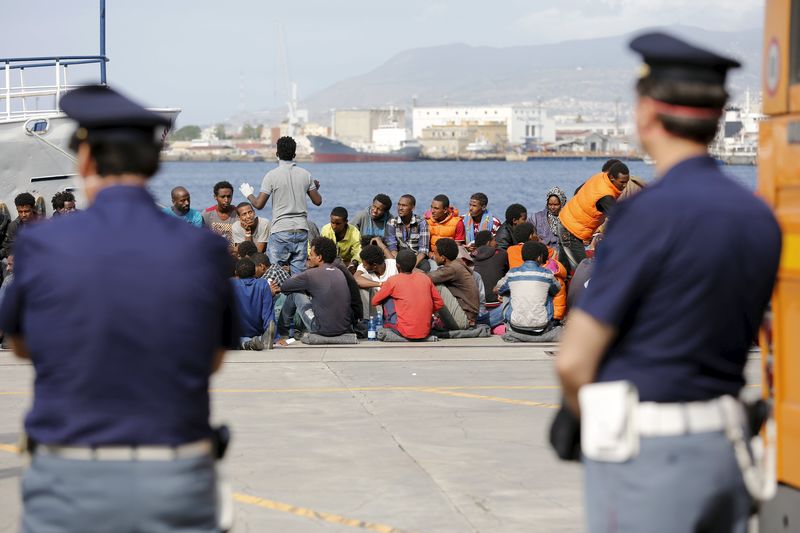 © Reuters. Migrants are disembarked from the Migrant Offshore Aid Station (MOAS) ship MV Phoenix in the Sicilian harbour of Messina