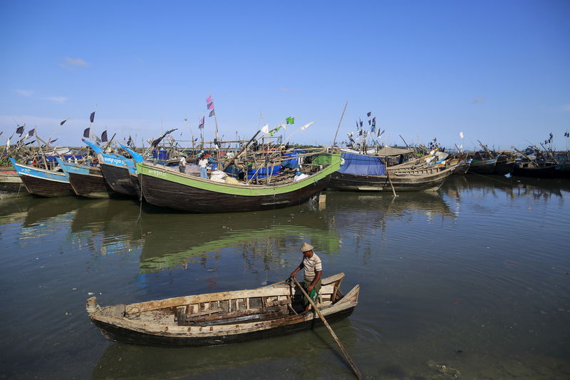 © Reuters. A man rows his boat at a fishing jetty near a refugee camp outside Sittwe