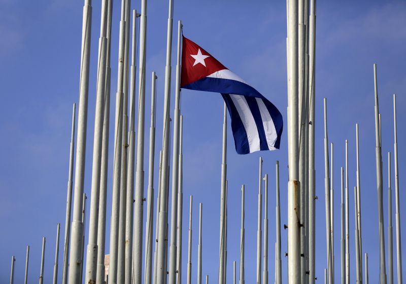 © Reuters. The Cuban flag flies in front of the U.S. Interests Section (background), in Havana