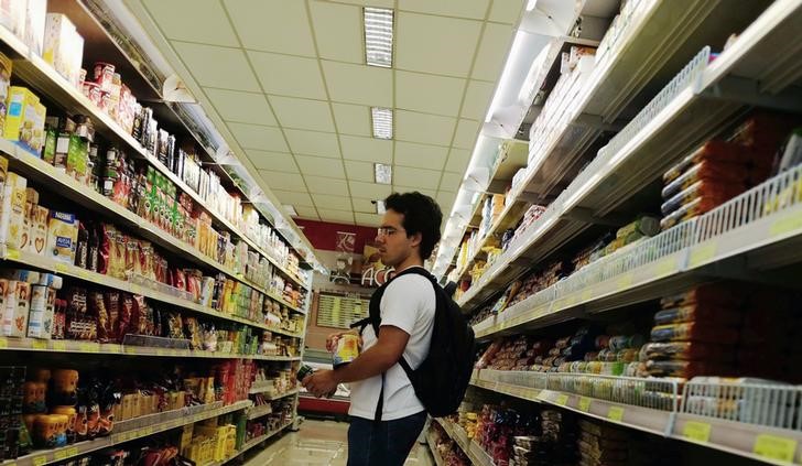 © Reuters. Cliente olha preços de alimentos num supermercado em São Paulo