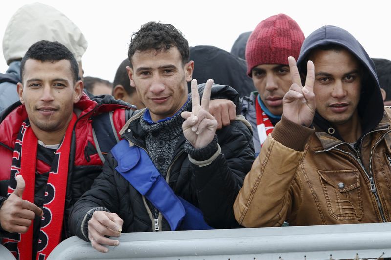 © Reuters. Moroccan citizen Touil Abdelmajid makes a victory sign as he arrives with migrants on the Italian navy ship Orione at Porto Empedocle harbour in Sicily