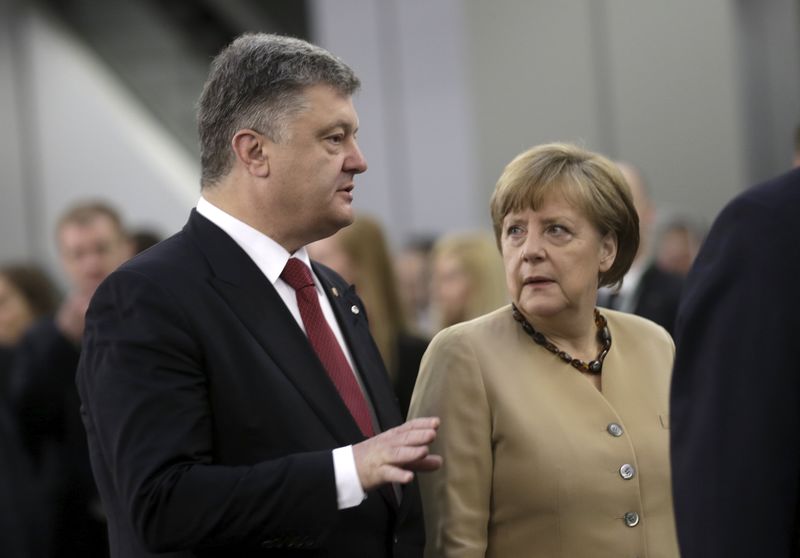 © Reuters. Germany's Chancellor Merkel listens to Ukraine's President Poroshenko before the Eastern Partnership Summit session in Riga