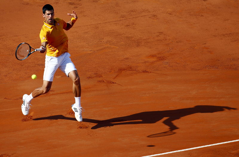 © Reuters. Djokovic of Serbia returns the ball to Federer of Switzerland during their final match at the Rome Open tennis tournament in Rome