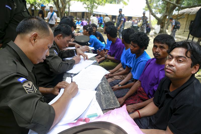 © Reuters. Rohingya Muslims from Myanmar, who were rescued by the Myanmar navy alongside Bangladesh refugees, are interviewed by immigration officers at a Muslim religious school used as a temporary refugee camp, at the Aletankyaw village in the Maungdaw township
