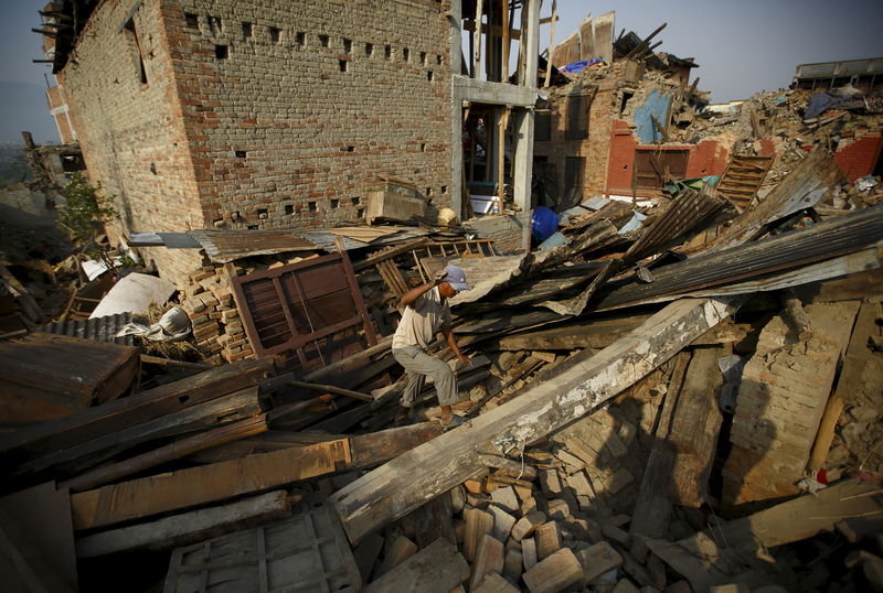 © Reuters. Homem caminha sobre destroços de casas destruídas por terremoto em 25/04 em Bhaktapur, no Nepal