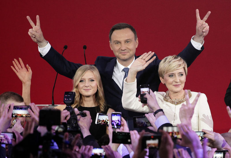 © Reuters. Duda, presidential candidate of the Law and Justice Party (PiS), his wife Agata and daughter Kinga flash Victory signs after the results of the exit polls on the second round of presidential elections in Warsaw