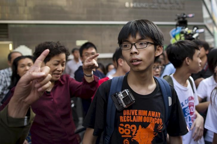 © Reuters. Student leader Joshua Wong is scolded by government supporters during a promotional event on electoral reform in Hong Kong, China 