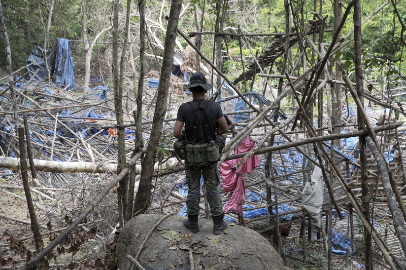 © Reuters. Policial observa acampamento abandonado por supostos traficantes de pessoas numa floresta da Malásia