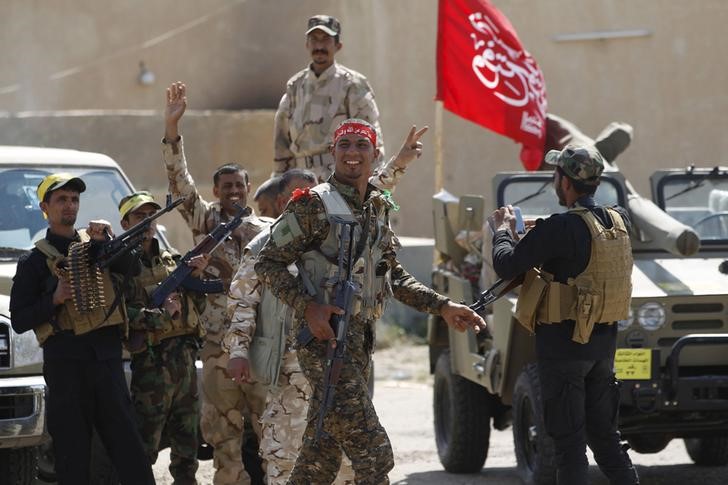 © Reuters. Hashid Shaabi allied with Iraqi forces against the Islamic State, carry their weapons as they prepare to attack Tikrit in the Iraqi town of Ouja