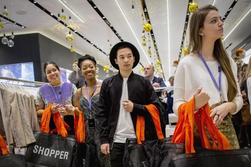 © Reuters. Employees wait to greet shoppers during British clothing retailer Topshop's grand opening of the chain's New York flagship store