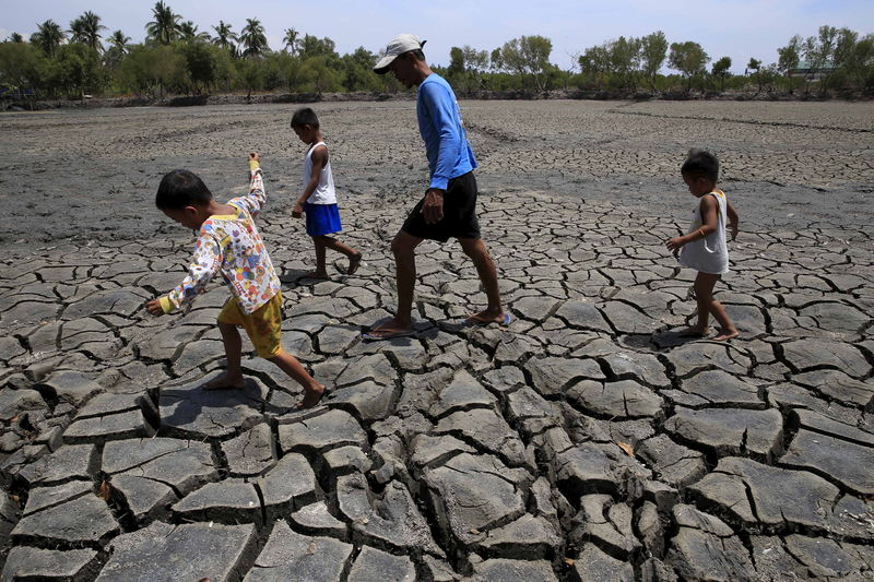 © Reuters. Filipinos caminham sobre um solo seco