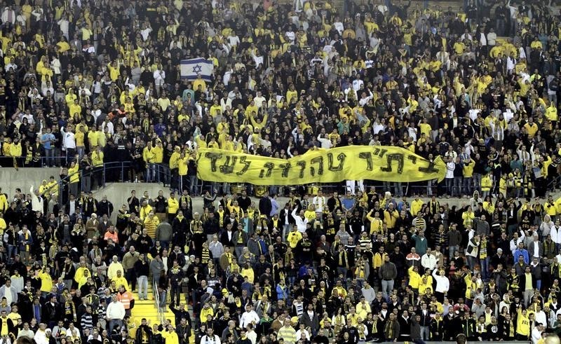 © Reuters. Supporters of Beitar Jerusalem soccer club hold a banner during a match in Jerusalem