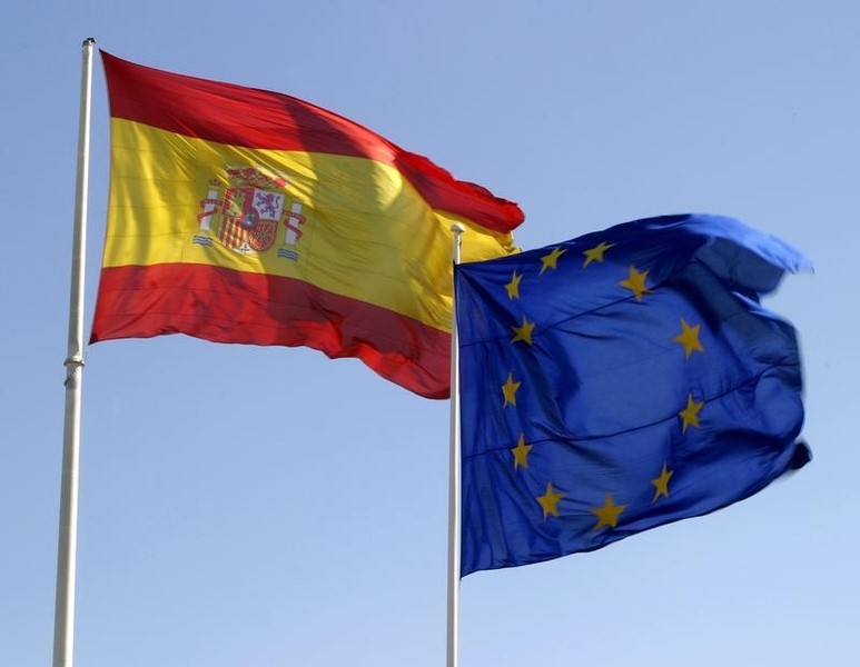 © Reuters. The European Union flag waves next to the Spanish flag in central Madrid.