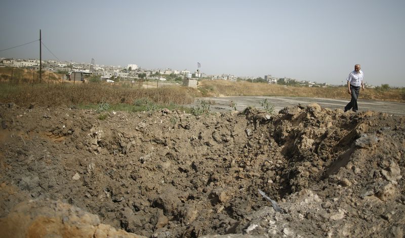 © Reuters. Palestinian man surveys the damage after an Israeli airstrike on a nearby Islamic Jihad training camp in Beit Lahiya in the northern Gaza Strip 