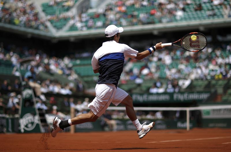 © Reuters. Kei Nishikori of Japan plays a shot to Thomaz Bellucci of Brazil during their men's singles match at the French Open tennis tournament at the Roland Garros stadium in Paris