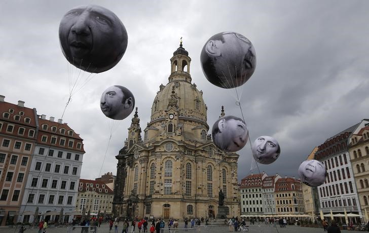 © Reuters. People watch balloons made by the 'ONE' campaigning organisation  depicting leaders of the countries members of the G7 in front of the Frauenkirche cathedral in Dresden