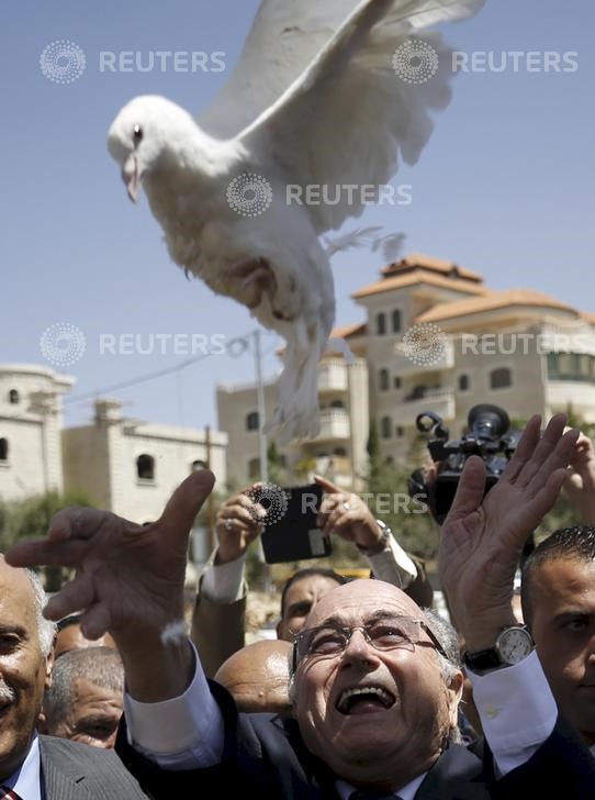 © Reuters. Presidente da Fifa, Joseph Blatter, solta uma pomba durante visita, na semana passada, a um vilarejo da cidade de Ramallah, na Cisjordânia.