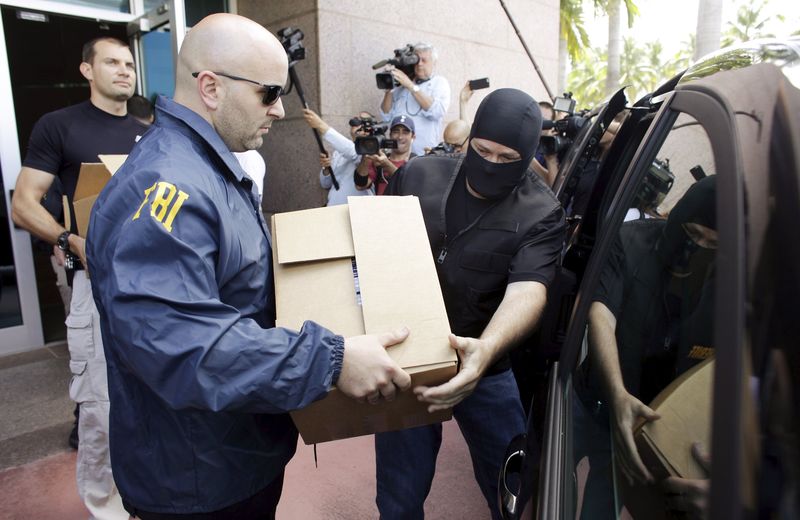 © Reuters. FBI agents carry boxes from the offices of marketing firm Traffic Sports during a search in Miami