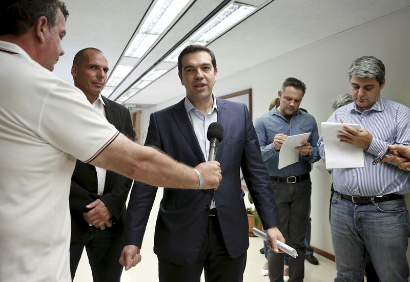 © Reuters. Greek PM Tsipras makes statements to the media as Finance Minister Varoufakis looks on after a meeting at the ministry in Athens 