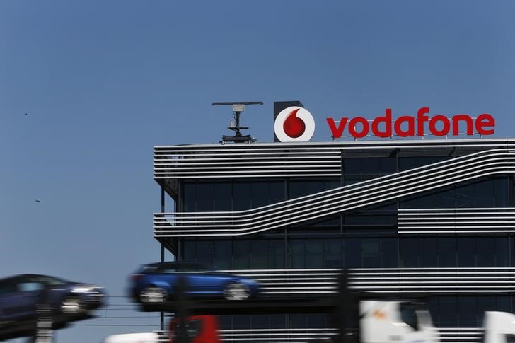 © Reuters. A truck carrying cars speeds past the headquarters of Vodafone in Madrid