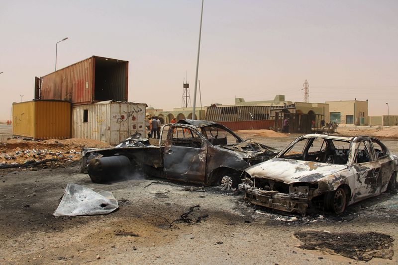© Reuters. Veículos são incendiados após explosão de homem-bomba num posto de controle na Líbia