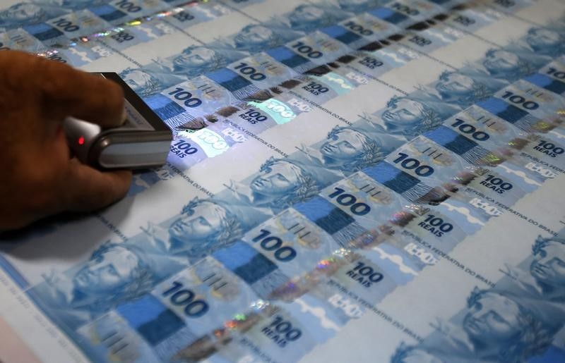 © Reuters. Funcionário inspeciona notas de 100 reais na Casa da Moeda