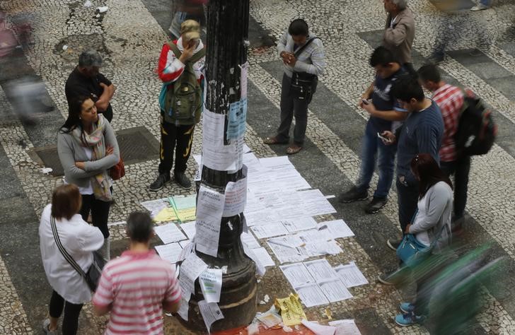 © Reuters. Pessoas olhando ofertas de emprego no centro de São Paulo
