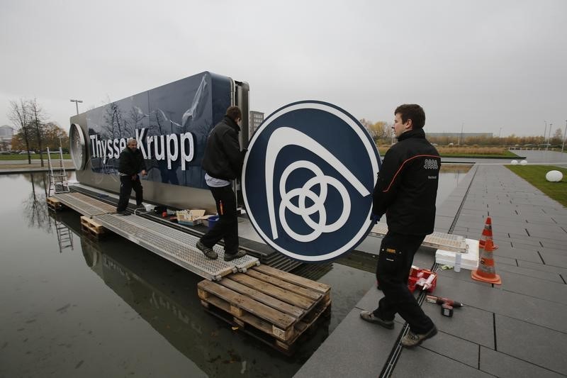 © Reuters. Electricians carry a cover with the logo of ThyssenKrupp AG at the company's headquarters in the western German city of Essen