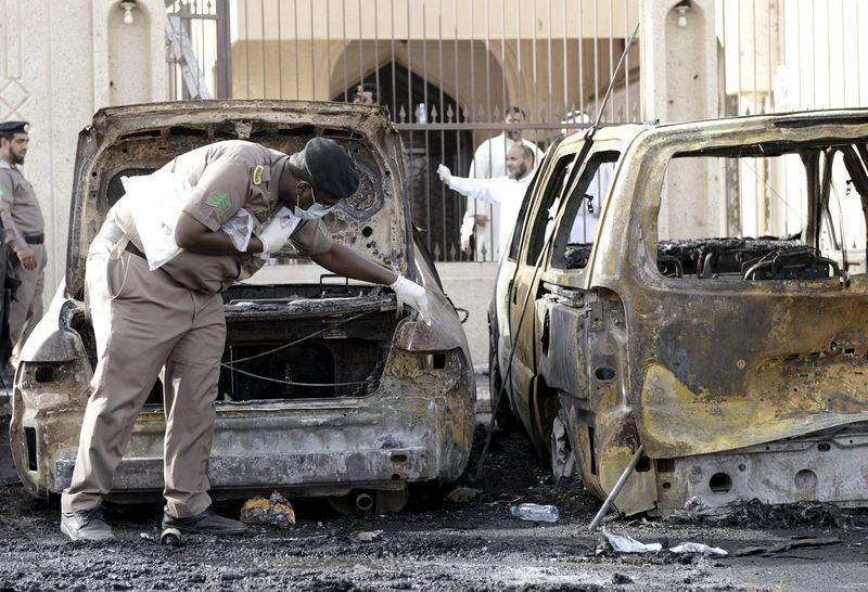 © Reuters. Polícia revista carro que explodiu em ataque em frente à mesquita de Dammam, na Arábia Saudita