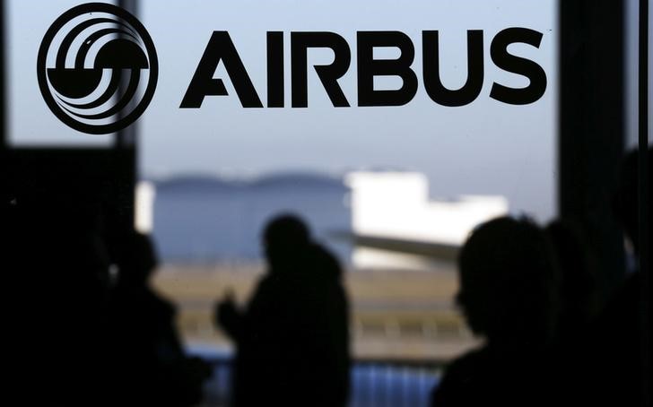 © Reuters. People are silhouetted past a logo of the Airbus Group during the Airbus annual news conference in Colomiers